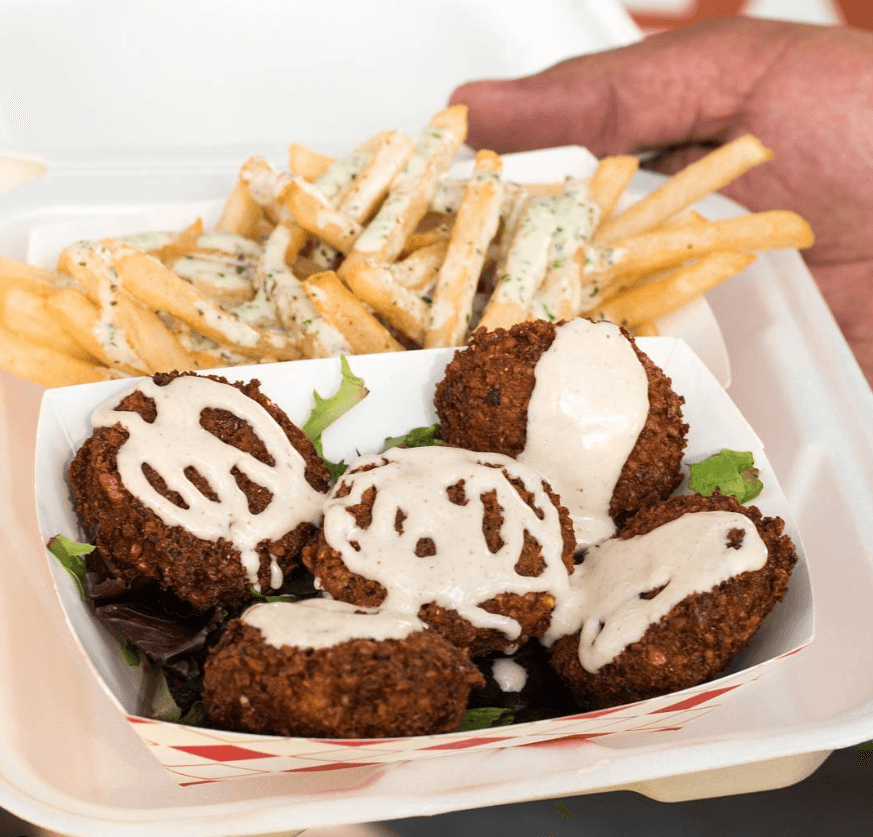 Crispy falafel bites drizzled with tahini sauce and garlic fries from Falafel Tree food truck