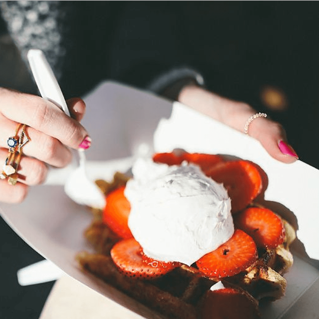 Guest eating a Waffle in Utah, food truck breakfast catering plate topped with strawberries and cream