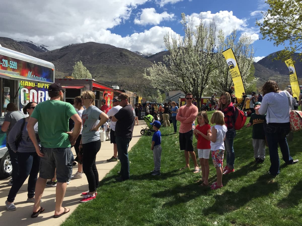 Food truck catering event with large queue of people waiting to be served
