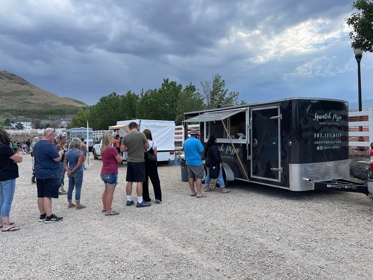 Guests lined up at the Squatch Pizza food truck at an outdoor event
