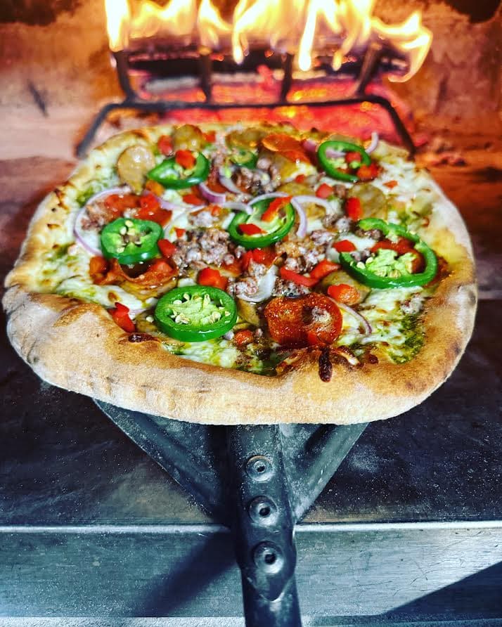 Wood-fired pizza with fresh toppings from a food truck, a popular pick for a company holiday party