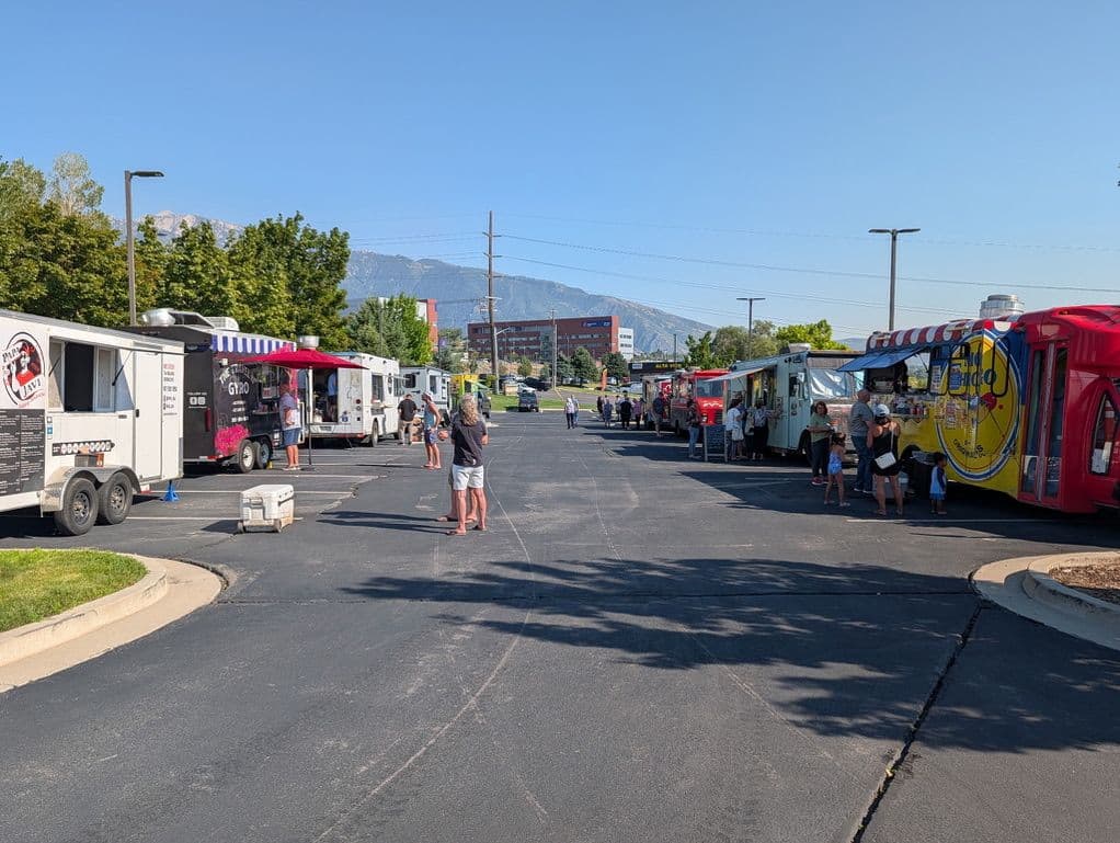 Multiple food trucks parked together at an outdoor lot, an example of food truck catering flexibility