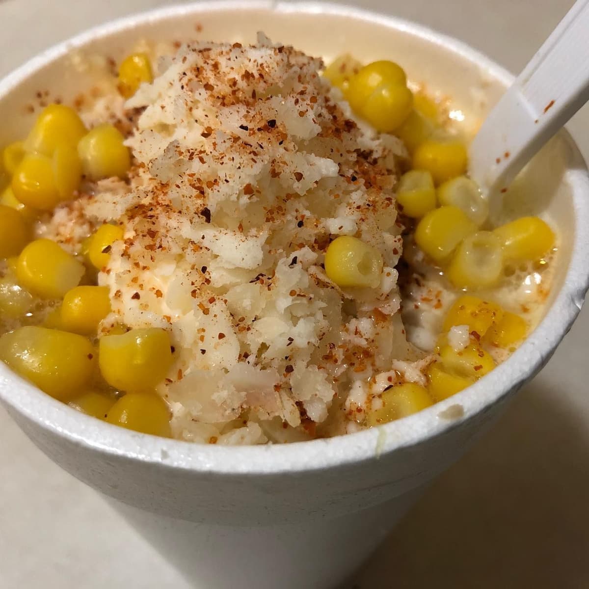Esquite corn cup with cotija cheese and tajin from a taco truck catering menu