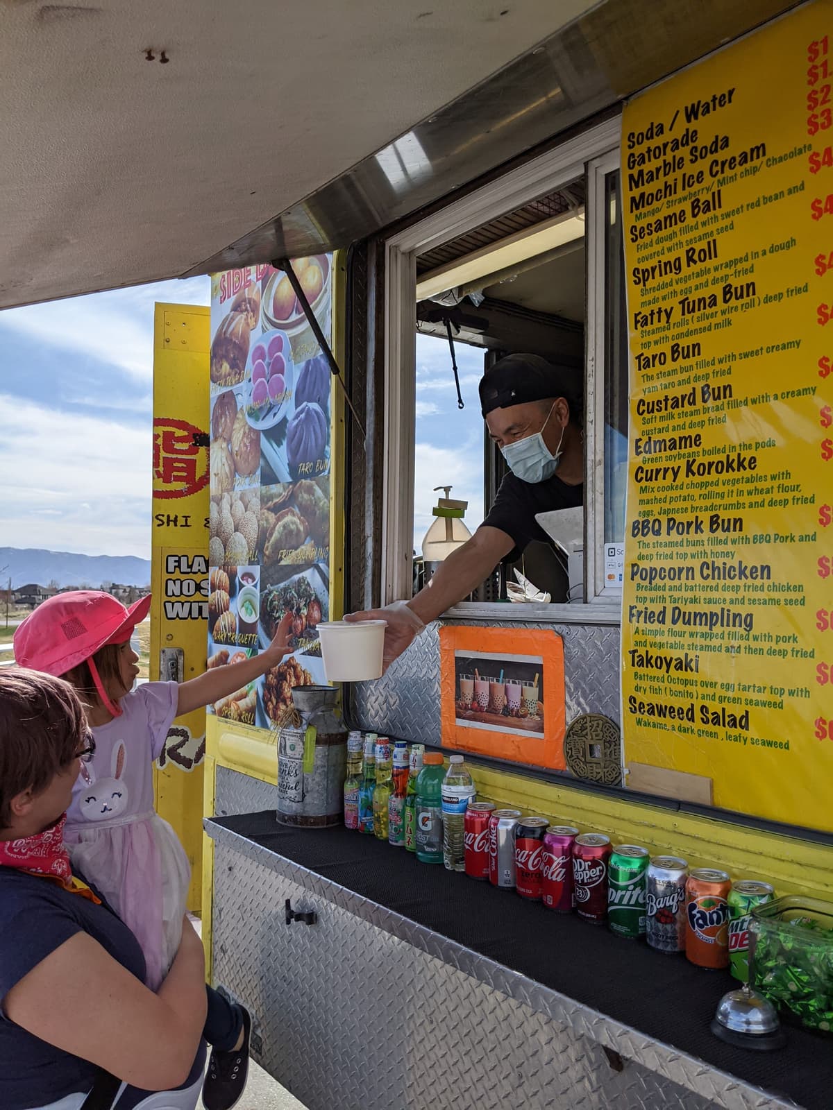 Food truck staff serving a customer directly from the truck window