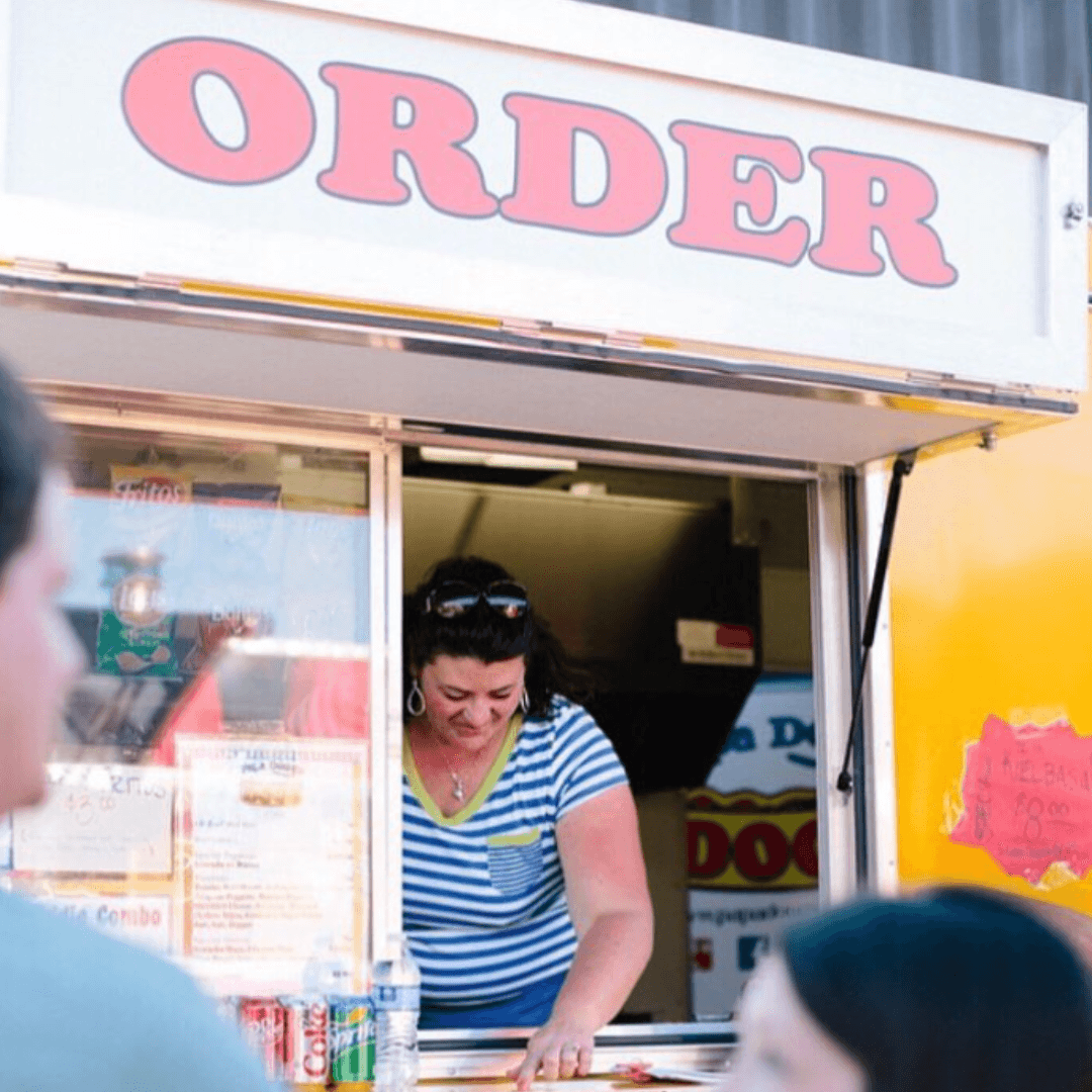 A food truck rental crew member taking orders at the window